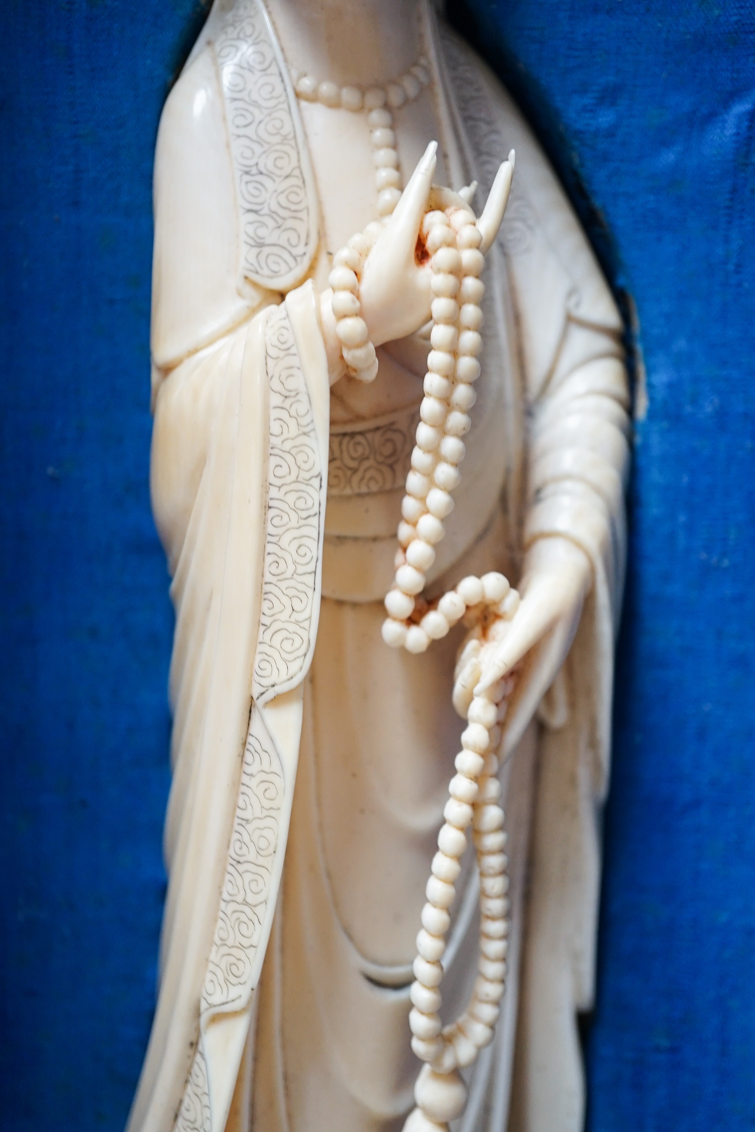 An early 20th century Chinese ivory figure of Guanyin holding a Buddhist rosary 25cm, wood stand and case